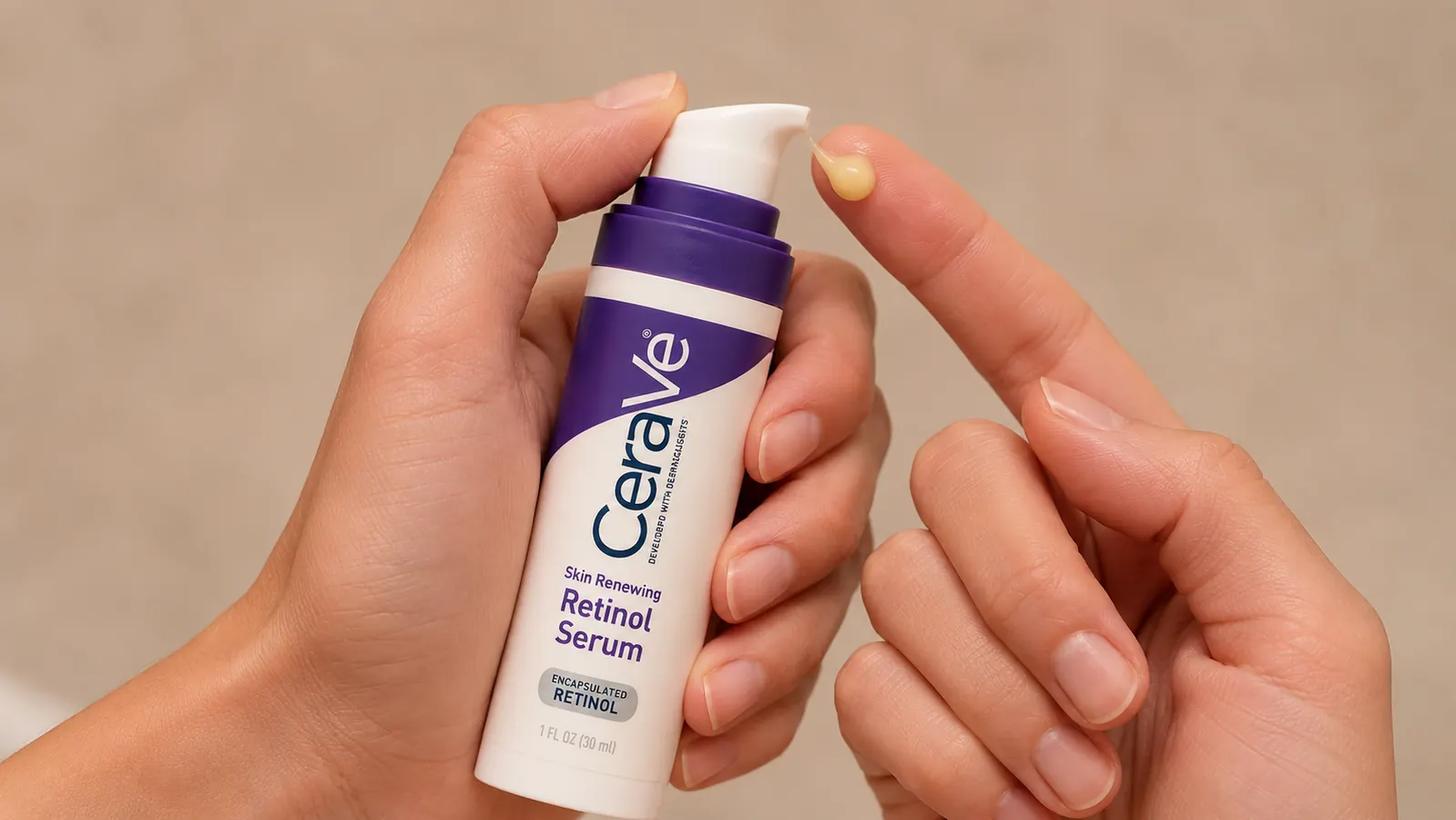 A hand dispensing a small drop of CeraVe Retinol Serum from the pump onto a fingertip, held above an open palm