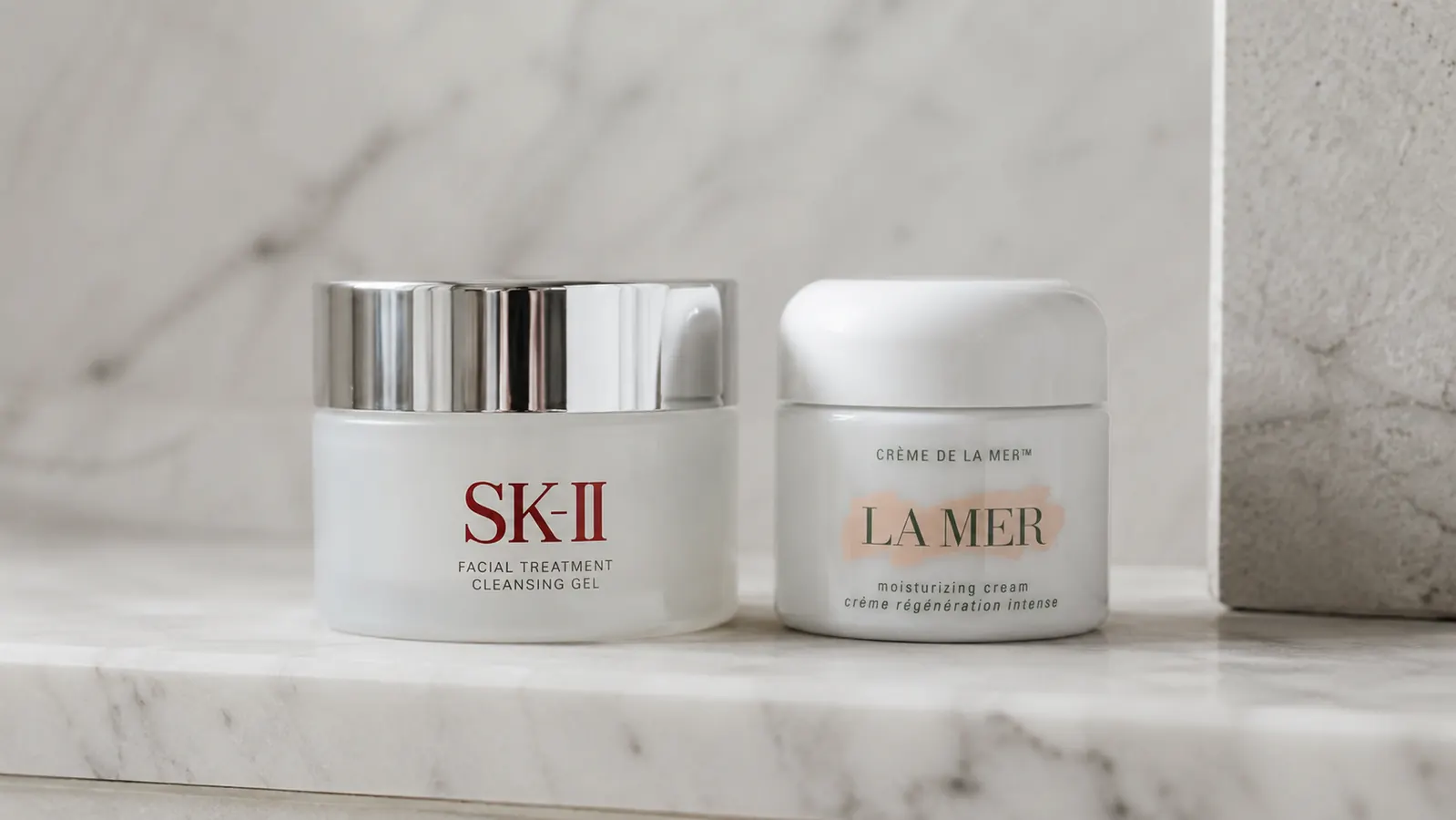 Side-by-side view of a Vanicream Daily Facial Moisturizer pump bottle next to a CeraVe Moisturizing Cream tub on a clean white bathroom shelf